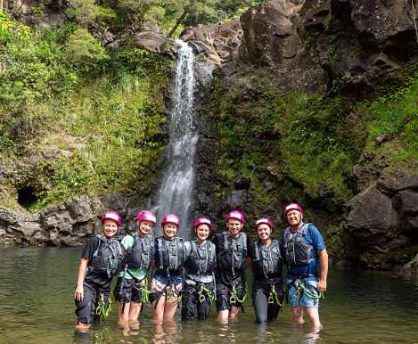 6 people part of the Rappel Maui Classic Rappelling Group Tour at the base of a Maui waterfall